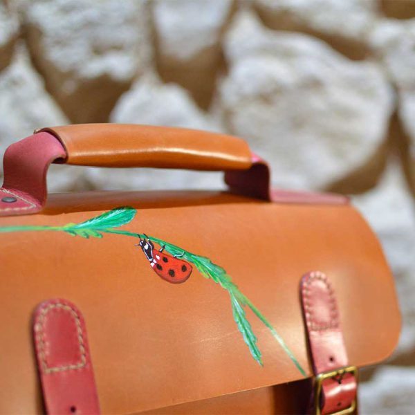 Detalle del dibujo de la mariquita sobre bandolera de cuero tipo satchel en tienda online
