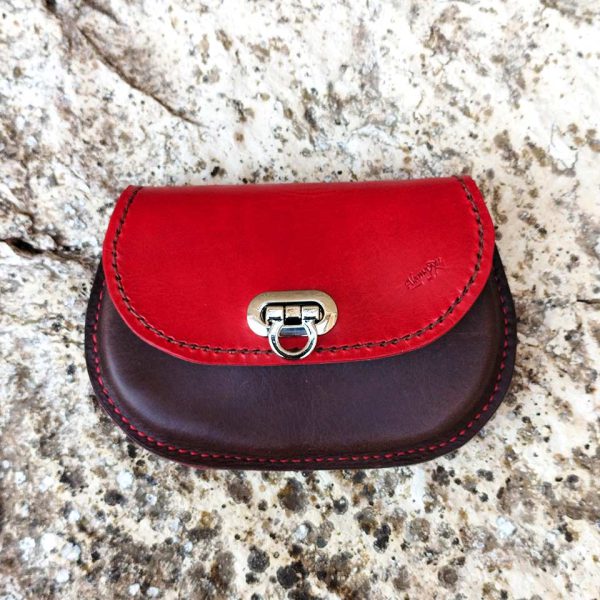 Monedero de cuero piezas de color marrón con tapa roja en tienda