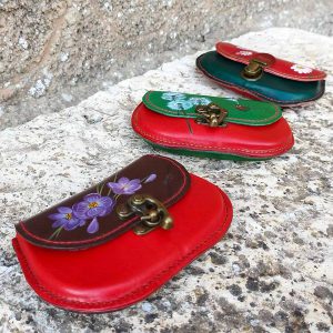 Monederos de cuero piezas de color pintados en varios colores con flores dibujadas a mano